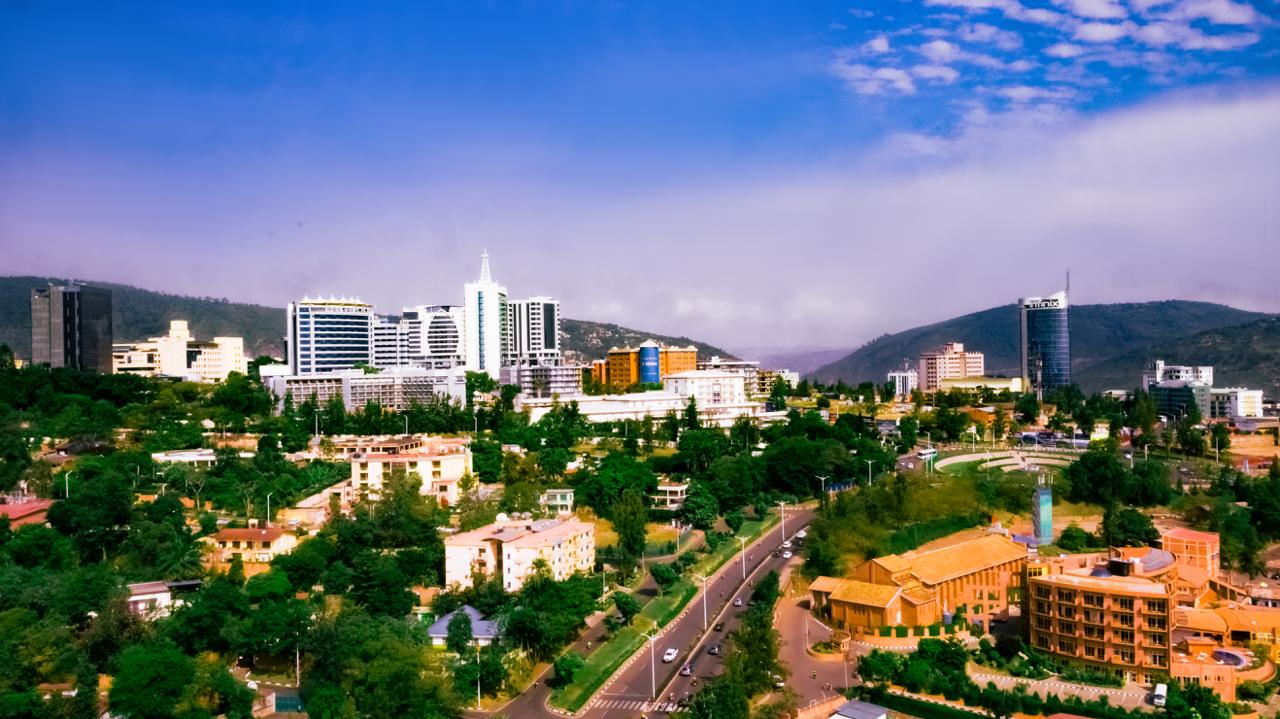 Aerial view across Kigali, with the city towers and the hills behind